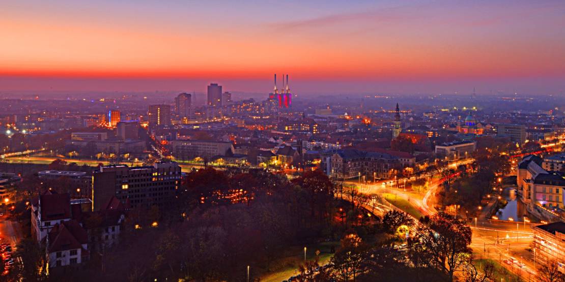 Blick aus größerer Höhe auf die Skyline von Hannover in der Dämmerung.